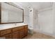 A well-lit bathroom with a wooden vanity, large mirror, tiled floor and walk in shower at 103 Wisteria Way, Stockbridge, GA 30281