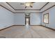 Bedroom featuring a tray ceiling, fan, and window, with a doorway leading to the hallway at 103 Wisteria Way, Stockbridge, GA 30281