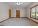 Neutral bedroom with two wood doors, a window with wood trim, and neutral carpet and paint at 103 Wisteria Way, Stockbridge, GA 30281