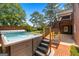 Modern hot tub with brick patio and stairs in a large backyard with steps to an elevated patio at 103 Wisteria Way, Stockbridge, GA 30281
