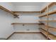 Walk-in closet with wooden shelving and carpeted flooring providing ample storage space at 103 Wisteria Way, Stockbridge, GA 30281