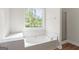 Bright bathroom with a large soaking tub and a window view at 185 Cold Harbor Ct, Sharpsburg, GA 30277