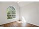 Bright bedroom featuring hardwood floors, a ceiling fan, and a large window offering natural light at 185 Cold Harbor Ct, Sharpsburg, GA 30277
