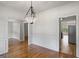 Open dining room featuring hardwood floors, chandelier, and views into kitchen and living areas at 185 Cold Harbor Ct, Sharpsburg, GA 30277
