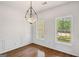 Dining room with elegant chandelier, wainscoting, and windows with wooded views at 185 Cold Harbor Ct, Sharpsburg, GA 30277