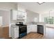 Well-lit kitchen featuring white cabinetry, modern appliances, and wood-look flooring at 185 Cold Harbor Ct, Sharpsburg, GA 30277