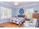 Bedroom with hardwood floors, blue walls, white trim, plantation shutters and a decorative quilt at 230 Haynes Rd, Moreland, GA 30259