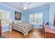 Bedroom with hardwood floors, blue walls, white trim, plantation shutters and a decorative quilt at 230 Haynes Rd, Moreland, GA 30259