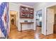 Hallway with hardwood floors, an antique cabinet, and an opening leading to a kitchen area at 230 Haynes Rd, Moreland, GA 30259