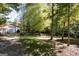 Outbuilding surrounded by lush trees, with a metal roof and a large garage door at 230 Haynes Rd, Moreland, GA 30259