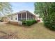 The backyard features a screened in porch, mature landscaping, and vinyl siding at 210 Brittany Chase, Fayetteville, GA 30214