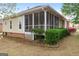 The backyard features a screened in porch, mature landscaping, and vinyl siding at 210 Brittany Chase, Fayetteville, GA 30214