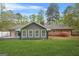 Back exterior of home featuring well-maintained lawn, gray siding, brick, and large windows at 3387 Oak Dr, Lawrenceville, GA 30044