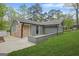 Charming single-story home with brick and gray siding nestled in a lush, green landscape at 3387 Oak Dr, Lawrenceville, GA 30044