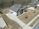 Aerial view showcases blue home's concrete driveway, attached garage, and manicured front lawn with flowerbeds at 270 Blue Point Pkwy, Fayetteville, GA 30215