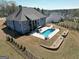 Aerial view displays a beautiful backyard with a swimming pool, patio, lounge chairs, and manicured hardscape at 270 Blue Point Pkwy, Fayetteville, GA 30215