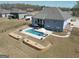Aerial view of a backyard featuring a patio with a pool, lounge chairs, and landscaped hardscape at 270 Blue Point Pkwy, Fayetteville, GA 30215