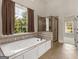 Bathroom featuring a jetted tub, shower, and large window at 249 Suffolk Way, Mcdonough, GA 30252
