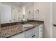 Bathroom vanity featuring granite countertops, white cabinetry, and bronze fixtures with a matching mirror at 249 Suffolk Way, Mcdonough, GA 30252