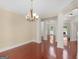Formal dining room with hardwood floors, elegant chandelier, and decorative columns to other rooms at 249 Suffolk Way, Mcdonough, GA 30252