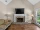 Cozy living room featuring a stone fireplace with TV and hardwood floors at 249 Suffolk Way, Mcdonough, GA 30252
