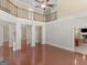 Open-concept living room featuring hardwood floors, columns, and a view of the upstairs balcony at 249 Suffolk Way, Mcdonough, GA 30252