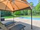 Lounge chairs sit under a shaded gazebo overlooking the pool and beautiful, green scenery at 249 Suffolk Way, Mcdonough, GA 30252