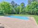 Beautiful blue pool and concrete pool deck surrounded by green grass and trees at 249 Suffolk Way, Mcdonough, GA 30252