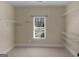Walk-in closet featuring neutral carpet, one window and built-in shelving at 249 Suffolk Way, Mcdonough, GA 30252