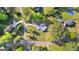 Aerial view of a home nestled among lush trees with a long driveway and expansive green lawn at 105 Hartford Pl, Fayetteville, GA 30214