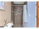 A modern shower with brown tile, a built in shower caddy, and updated hardware at 105 Hartford Pl, Fayetteville, GA 30214