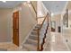 Inviting foyer featuring a carpeted staircase with wood banister and travertine tile flooring at 105 Hartford Pl, Fayetteville, GA 30214