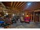 Unfinished basement with exposed wooden framing, a red chair, and 