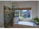 Bathroom featuring a soaking tub, tiled walk in shower, and large window at 1730 Carlington Ct, Grayson, GA 30017