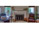 Close-up of a fireplace with marble surround and decorative mantle, flanked by chairs at 1730 Carlington Ct, Grayson, GA 30017