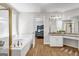 Bright bathroom boasts a soaking tub, vanity with granite countertops, and a view into an adjacent bedroom at 3139 Players Dr, Jonesboro, GA 30236