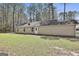 Exterior view of home from backyard with a grassy lawn and mature trees at 1109 Allen Rd, Grantville, GA 30220