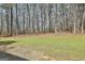 Backyard featuring a grassy area surrounded by mature trees, with a concrete patio area at 1109 Allen Rd, Grantville, GA 30220