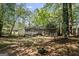 Tree-filled backyard featuring a home with a small elevated deck and surrounding greenery at 385 Lakeshore Dr, Stockbridge, GA 30281
