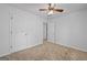 Bright bedroom featuring plush carpet, neutral walls and a ceiling fan with light fixture at 385 Lakeshore Dr, Stockbridge, GA 30281