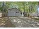 Single-story home featuring a two-car garage and inviting front porch surrounded by mature trees at 385 Lakeshore Dr, Stockbridge, GA 30281