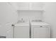 Laundry room with white washer and dryer units and wire shelves above at 385 Lakeshore Dr, Stockbridge, GA 30281