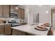 Bright kitchen with a large island, stainless appliances, quartz countertops, and modern fixtures at 591 Parnassus Rd, Locust Grove, GA 30248