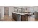 View of the kitchen island with stainless steel appliances, view into the dining and living areas at 591 Parnassus Rd, Locust Grove, GA 30248