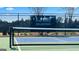 A close up of the pickleball court fence with an Oak Ridge Meadows banner and a partial view of the surrounding neighborhood at 591 Parnassus Rd, Locust Grove, GA 30248
