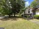 Split-level home with well-manicured lawn surrounded by mature trees in a residential area at 9041 Southcrest Ct, Jonesboro, GA 30238