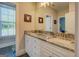 Light-filled bathroom with double sinks, granite counters, and doorway to bedroom at 1461 Thomas St, Conyers, GA 30094
