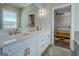 Bright bathroom features white cabinets with double sinks and gold hardware, and doorway to main bedroom at 1461 Thomas St, Conyers, GA 30094