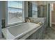 Bright bathroom features white soaking tub, tiled floors, and large windows with outdoor views at 1461 Thomas St, Conyers, GA 30094