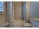 Bathroom featuring a shower-tub combo, grey tile surround and patterned shower curtain at 1461 Thomas St, Conyers, GA 30094